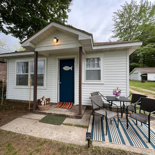 Overall:  the front of the cabin and the outdoor dining furniture