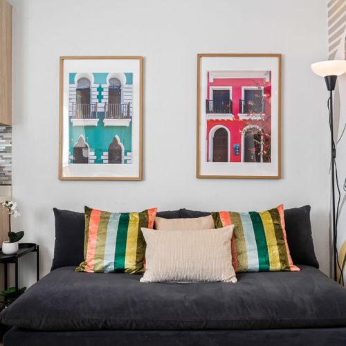 Stylish & Connected: This modern living space features a large TV for your entertainment, complemented by vibrant artwork and a comfortable setup perfect for lounging or family time.