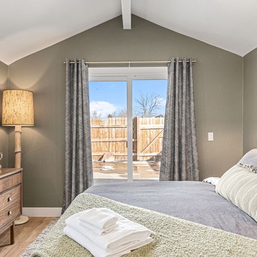 - sunshine pouring through sliding doors with views of the private fenced patio
- earth toned walls, vaulted ceiling, & layered textures make this space feel calm
- enjoy thoughtful touches like rolled towels, modern dresser, & soothing natural light