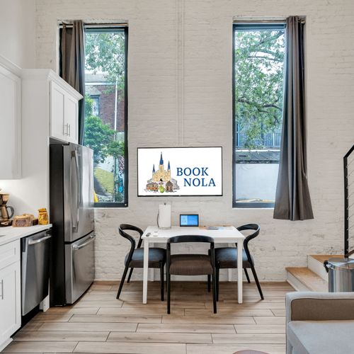 This sleek kitchen and dining space features stainless steel appliances, tall windows, and a cozy seating area. Ideal for guests who love to cook or enjoy takeout from nearby local gems.