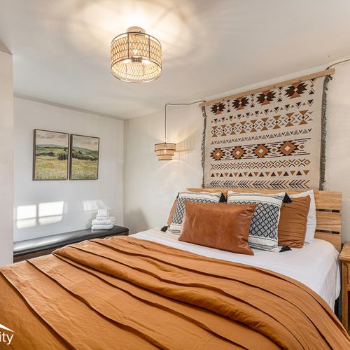 Discover a stylish retreat in the lower level bedroom, featuring a comfortable queen-size bed with fresh linens and cozy bench nook.