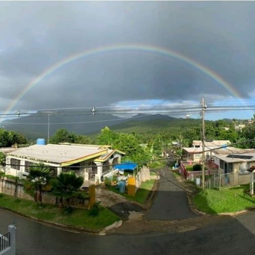 Experience magical moments! This stunning view captures the vibrant local landscape, often graced by beautiful rainbows, promising an unforgettable backdrop to your stay."