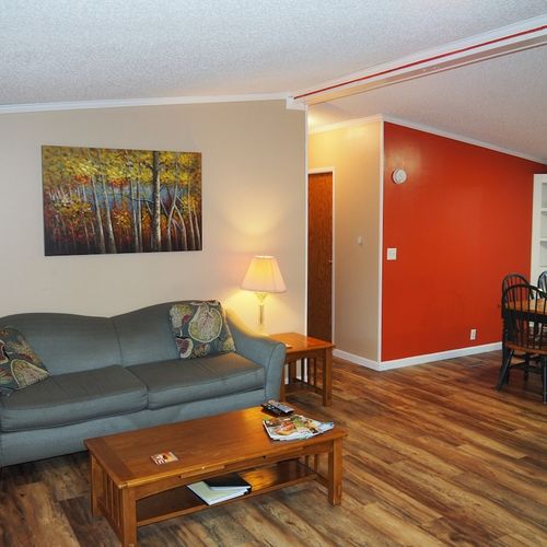 This photo shows part of the living room, the hallway that leads to bedrooms #2 and #3 and the second bathroom, and it also shows the dining area.
