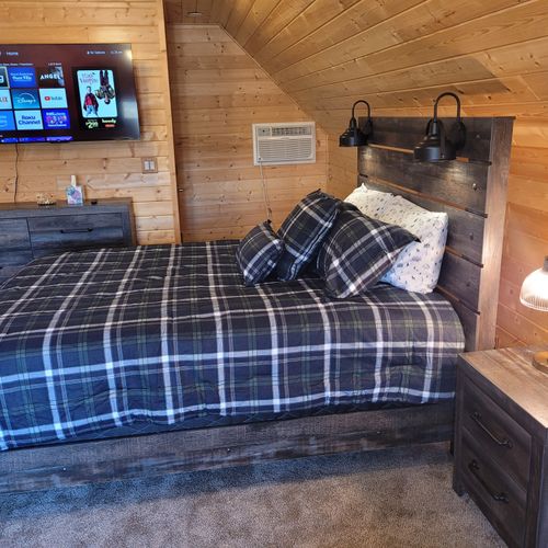 BEDROOM #3 (SECOND FLOOR BUNK ROOM ABOVE GARAGE):  Features 2 queen-size beds, a comfy chair, wall A/C unit, wall heater, electric fireplace, 2 nightstands, a dresser, mini refrigerator, and live streaming television (via Sling).