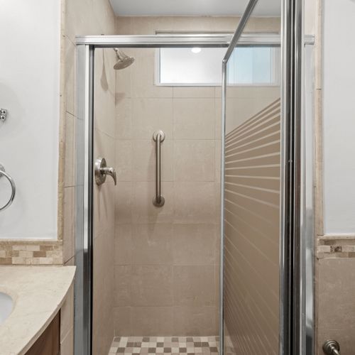 Bright and modern bathroom featuring a spacious walk-in shower with clear glass doors for an open feel.