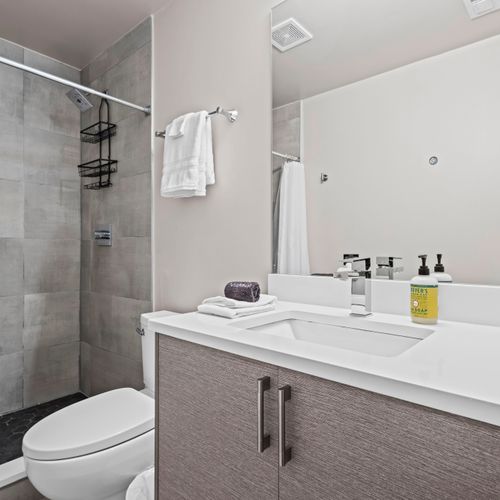 Spotless bathroom with walk-in shower, clean towels, and fresh essentials.