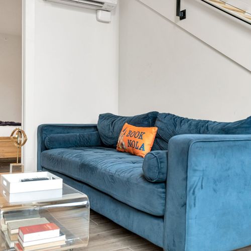 Bold velvet sofa paired w/ a modern acrylic coffee table & cozy touches.