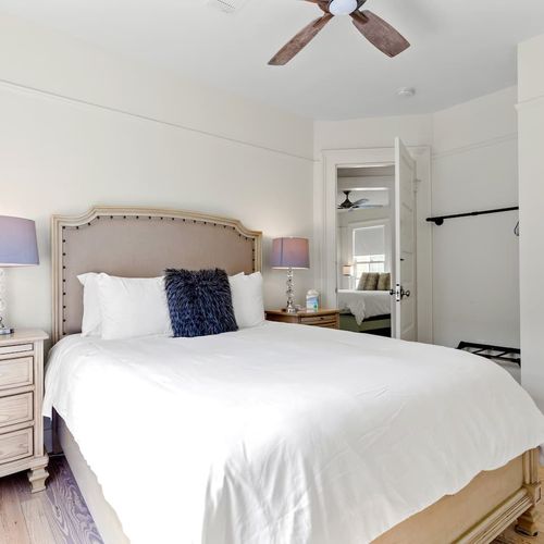 First bedroom w/ storage racks & a cozy bed.