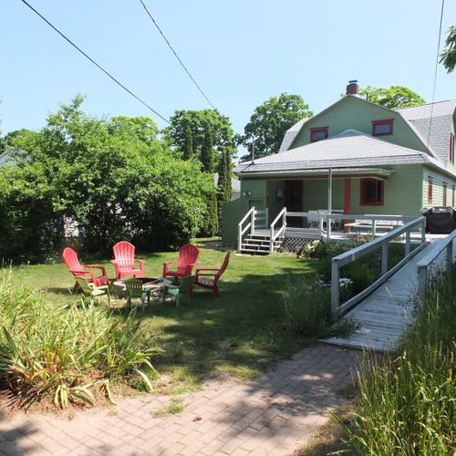 Exterior:  the back of the house showing the back porch, ramp, backyard, and fire pit.