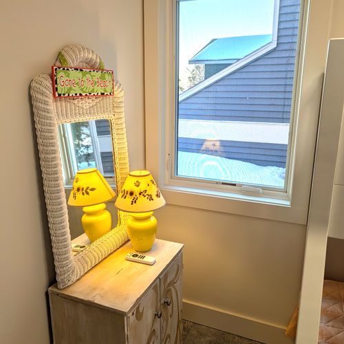 BEDROOM #2 (MAIN FLOOR):  Features a twin-on-full bunk bed, ceiling fan with safety guard, dresser, mirror, closet, and lamp.