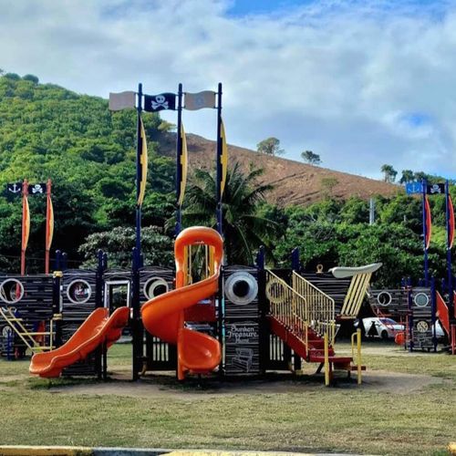 Adventure and culture combine! A fun playground and the iconic Puerto Rico flag monument set against a beautiful backdrop.