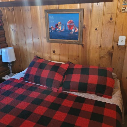 Bedroom #1:  features a queen-size bed, nightstand, lamp, mirror, dresser, and clothes rack.