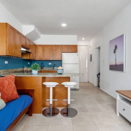 Two white stools are tastefully placed at the breakfast bar, blending seamlessly with the countertop.