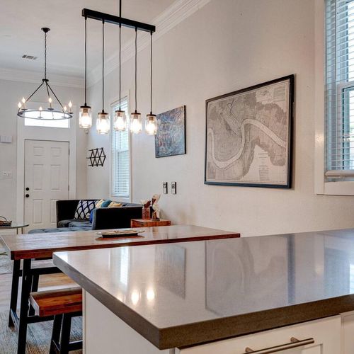 Stylish dining area w/ statement pendant lights & a wood table — a great place to gather.