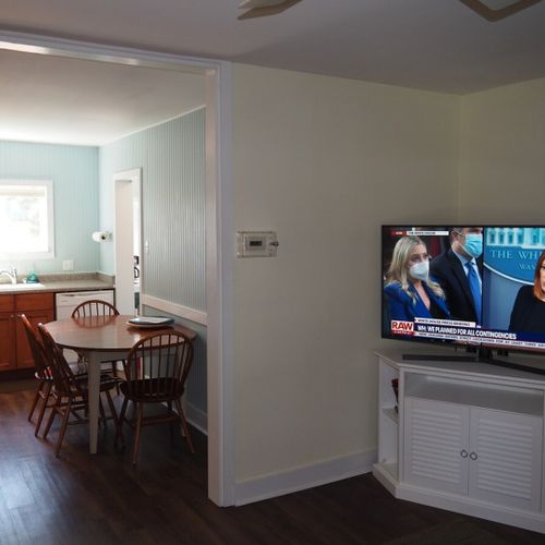 Living room: the apartment has a cozy living room with a sofa, chair, ceiling fan, and live streaming television.