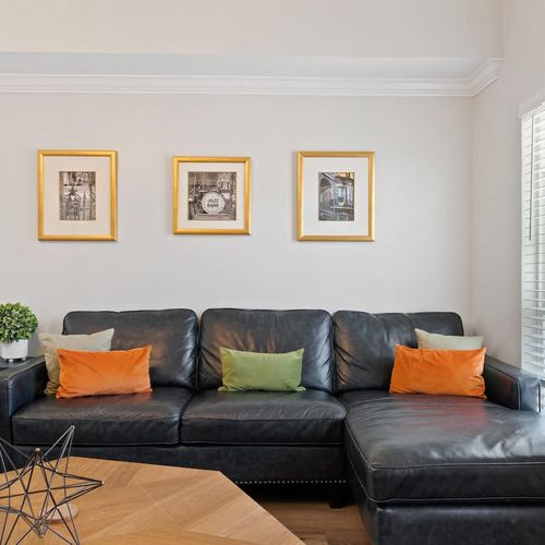 Roomy living area w/ plush sofas & warm accent pillows, perfect for group hangouts.