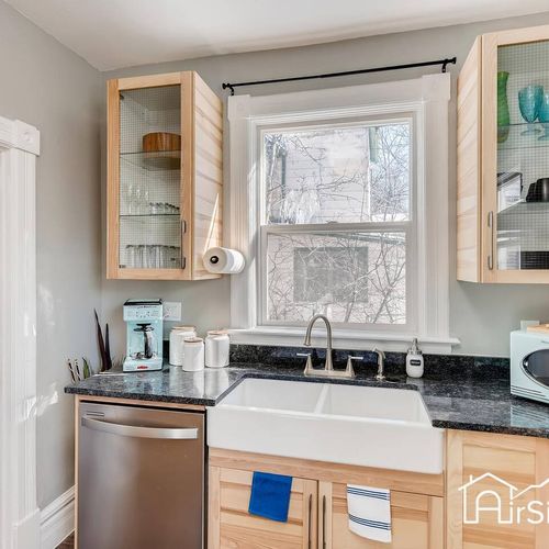 - stunning farmhouse sink framed by glass front cabinets and granite counters
- includes a modern dishwasher, open shelving, and kitchen essentials
- bright, polished setup perfect for prepping meals or morning coffee