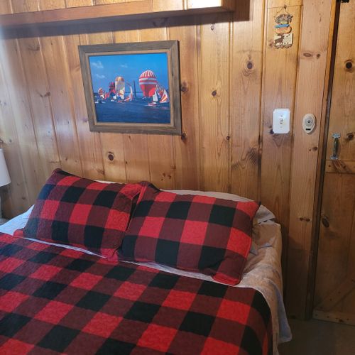 Bedroom #1:  features a queen-size bed, nightstand, lamp, mirror, dresser, and clothes rack.