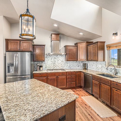 A modern kitchen with stainless steel appliances and a sleek granite countertop, perfect for preparing your favorite meals, just like at home.