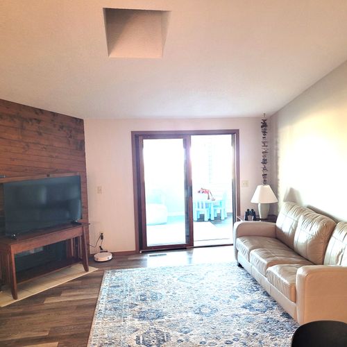 LIVING ROOM:  The home has a comfy living room with a wood fireplace.  (The television is now above the fireplace mantle.)  Note that the sliding doors lead out to the sunroom.