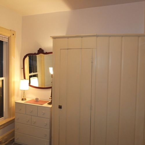 Bedroom #2 (main floor):  features a full-size bed, mirror, dresser, and closet.