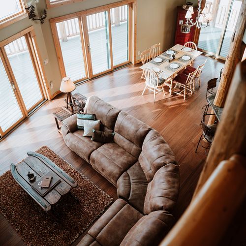 Elevated view from the loft showcasing the spacious and sunlit living area below, exuding warmth and openness.