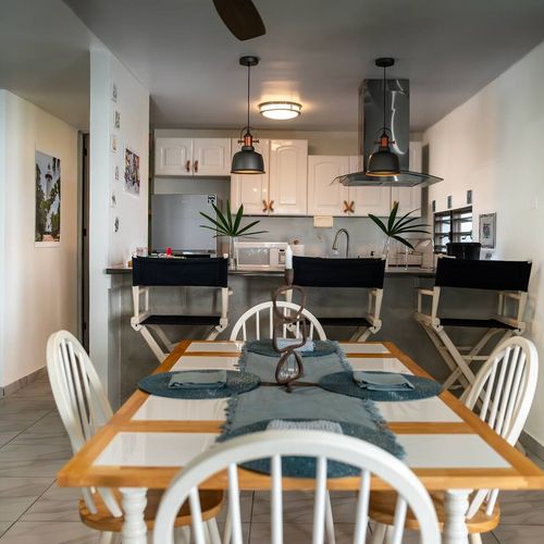 Experience our spacious open-concept living! This inviting dining area flows seamlessly into a well-equipped kitchen, perfect for meals and socializing during your stay.