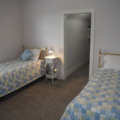 Bedroom #3:  all 3 bedrooms are upstairs. This bedroom features two twin-size beds, a nightstand with a lamp, a dresser with a mirror, and a large closet.
