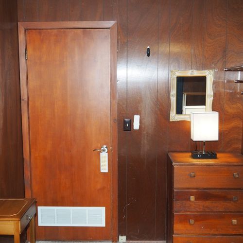 Bedroom #1:  features a queen-size bed, dresser, chair, lamps, and a ceiling fan.