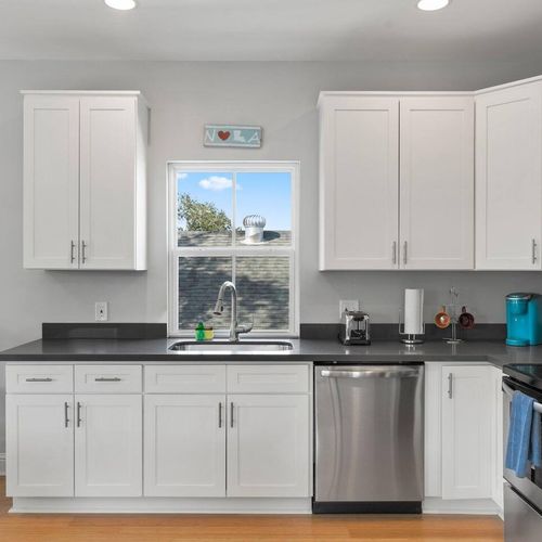 Bright kitchen w/ dark countertops & everything you need for home-cooked meals.