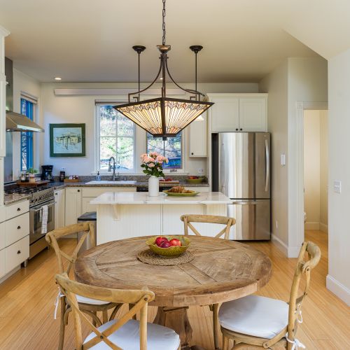 Light-filled chef’s kitchen with marble island and designer dining area.