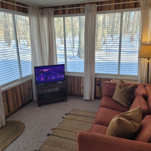 Living room #2:  the cabin has a section that was added on to the original cabin that now includes a sofa, lots of windows, and a smart television with roku.