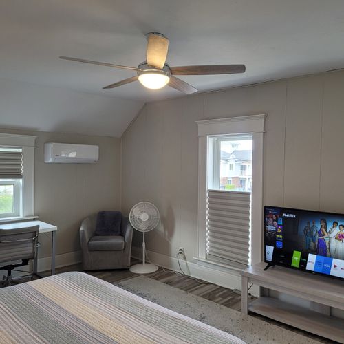 Bedroom #2 (second floor):  huge upstairs bedroom with a king-size bed, nightstands, lamps, 2 dressers, private television with live streaming, mini-split a/c unit, ceiling fan, desk with chair, comfy chairs, and a closet.