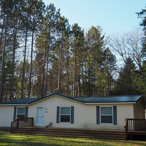 A nice overview of the front of the house, highlighting the front porch and the huge pine, cedar, and hemlock trees in the backyard.
