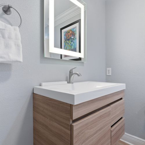 Modern vanity w/ vessel sink and clean, polished finishes.