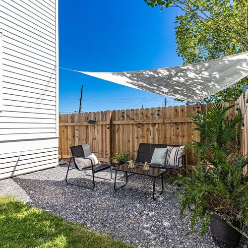 Private outdoor retreat w/ cozy seating tucked among lush greenery.