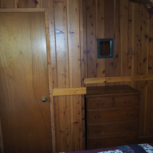 Bedroom #2 (main floor):  features a queen-size bed, nightstand with a lamp, a dresser, and a closet.