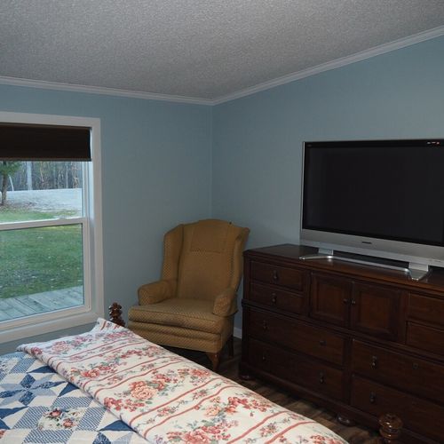 Bedroom #1 (master bedroom):  another angle showing the bedroom window (that faces the front yard), the chair, one of the dressers, and the television that has cable television.