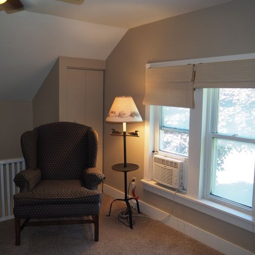 Living room:  very comfortable living room with sofa, coffee table, chair, lamp, and window a/c unit.