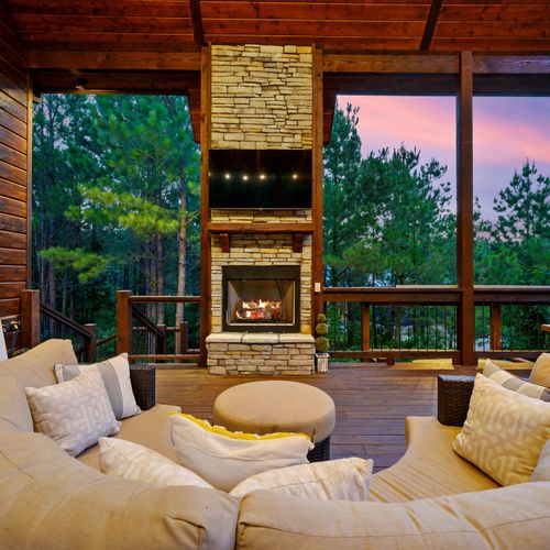 The covered deck has a large sectional around the fireplace and tv!