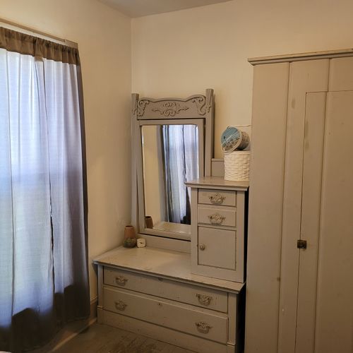 BEDROOM #1 (MAIN FLOOR):  Features a queen-size bed, nightstands, a dresser, mirror, and closet.