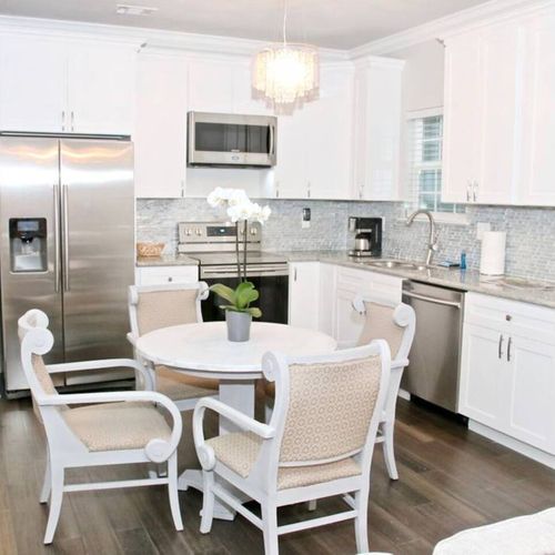 Cook & gather in the fully stocked kitchen w/ a sunlit dining area.