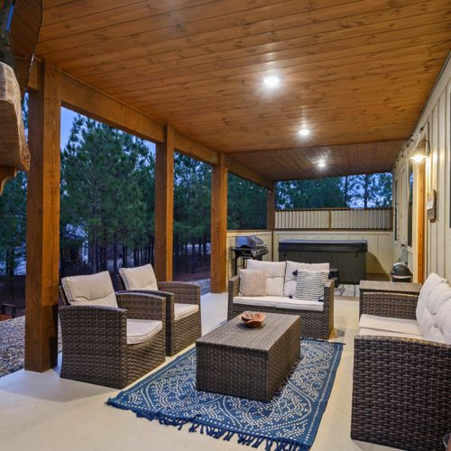 Outdoor furniture nestled around the fireplace and tv.
