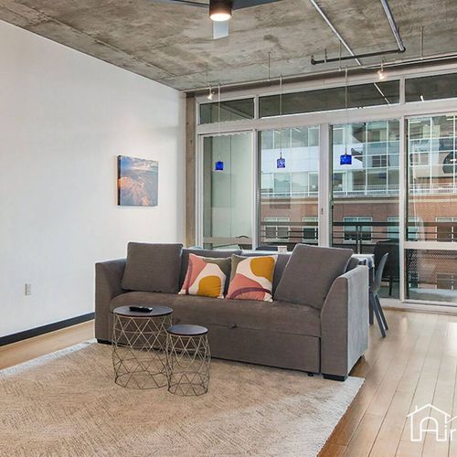 - enjoy bright daylight in this spacious lounge with floor to ceiling sliding doors
- sleek urban decor includes a plush rug and geometric accent tables
- ideal spot for lounging between city adventures or work from home sessions