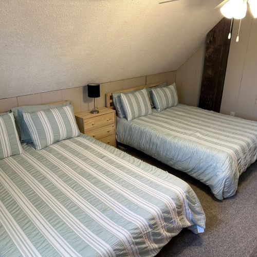 Bedroom #3 (upstairs):  features two queen beds, a ceiling fan, a nightstand, a lamp, and 2 large closets.