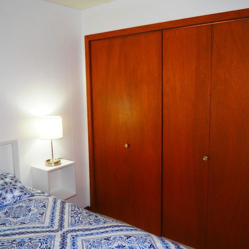 Bedroom #1:  features a queen-size bed, nightstands with lamps, ceiling fan, chair, dresser, closet, and full-length mirror.