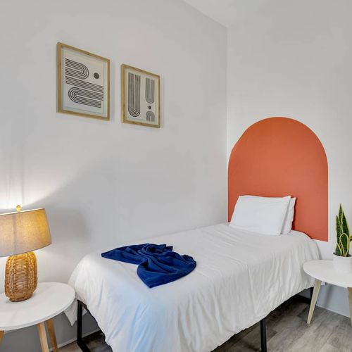 Twin bedroom w/ bold arched headboards & blue accents — fun, modern & full of character.