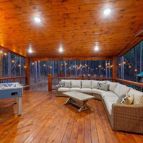 The covered outdoor patio has an oversized outdoor sectional and foosball.
