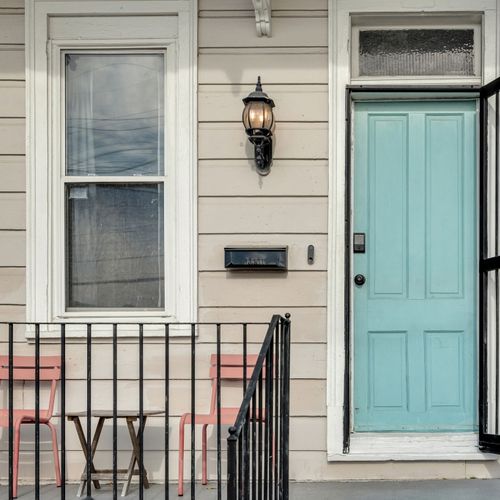 Charming teal front door w/ classic ironwork — full of local character.