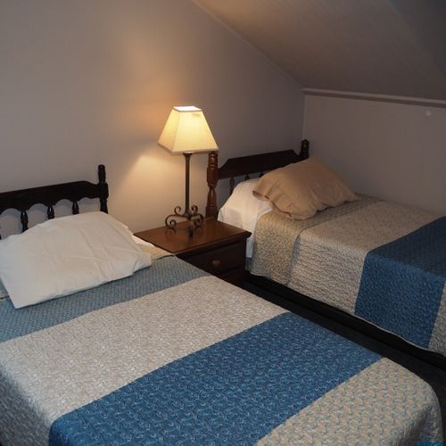 Bedroom #2:  features 2 twin beds, window a/c unit, nightstand, lamp, and mirror.